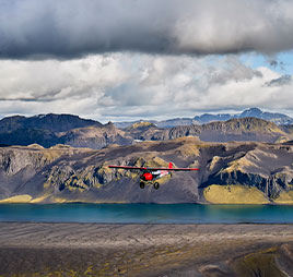 Photo of a plane flying over mountains. Link to What to Give. Photo of a plane flying over mountains. Link to What to Give.